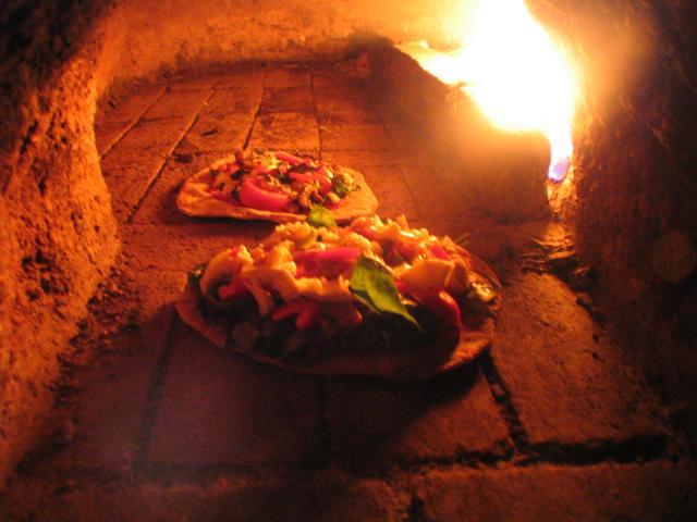 Pizzas baking in the cob oven