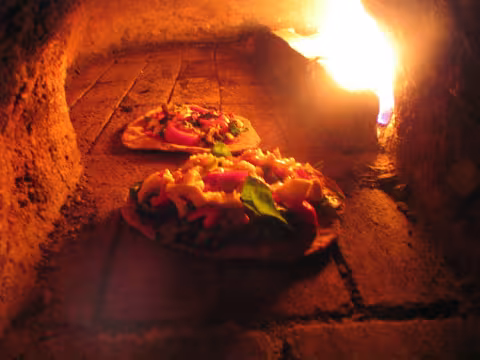 Pizzas baking in the cob oven